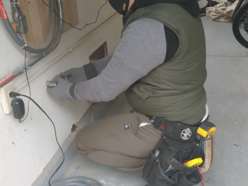 Electrician performing outlet wiring in a Charter Oak garage